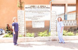 Two students pose with the sign outside the hospital in Iringa, Tanzania.